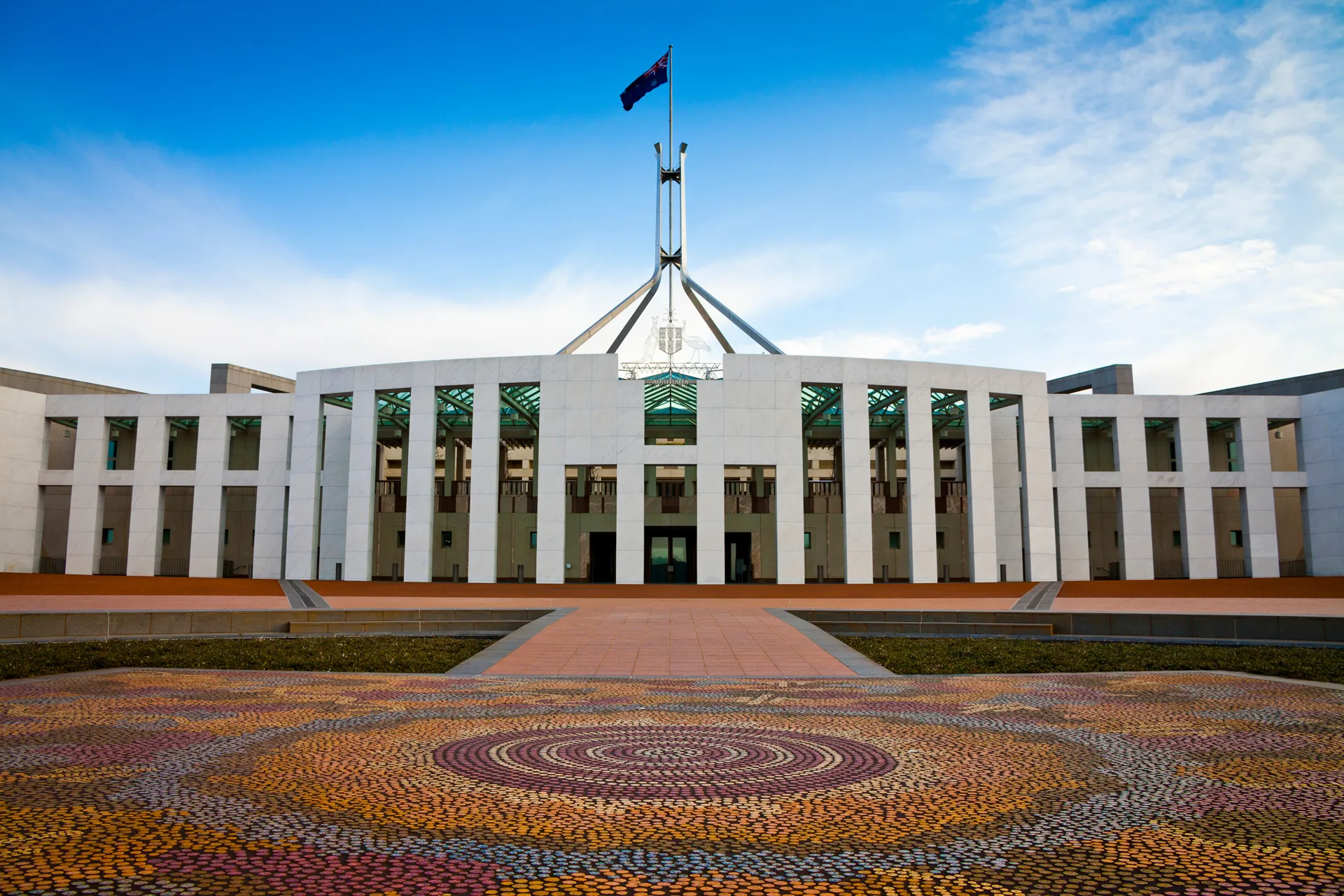 A photo of Parliament House in Canberra, Australia, beneath a blue sky.