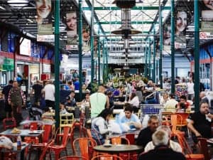 A photo of Prestom Market with customers eating at tables in the foreground