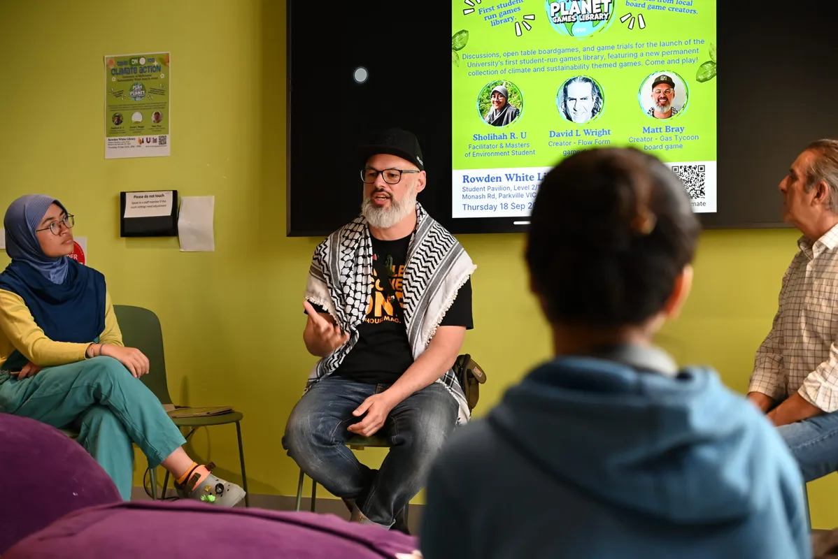 A panel of two speakers sitting in front of an audience at Melbourne University.