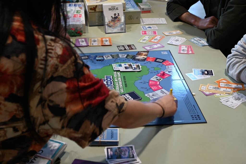 Students playing Gas Tycoon, a satirical board game about the fossil fuel industry.