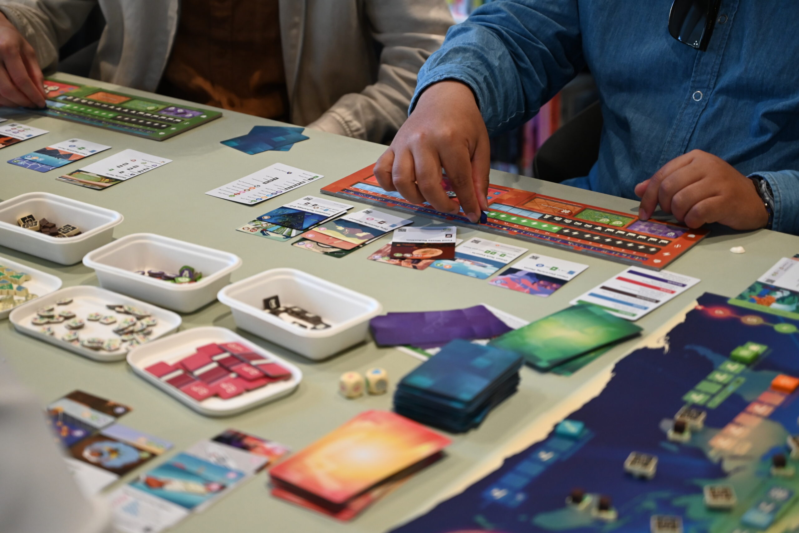 Students playing the Daybreak board game at the Melbourne University games library.