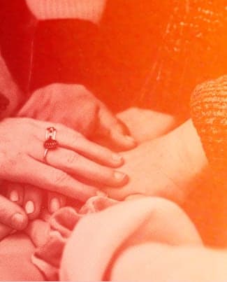 Photo of hands taken as people stand in a circle and take turns to put their hand in the centre, then raise up their hands while shouting a cheer, usually performed by a group before an action is taken